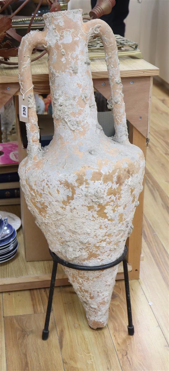 A large pottery amphora possibly from antiquity, later stand